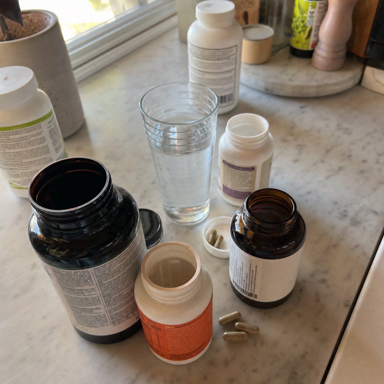Assorted supplement bottles on a kitchen counter